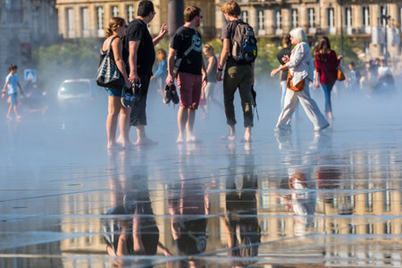 FRANCE, BORDEAUX - SEPTEMBER 20: People having fun in a mirror fountain in front of Place de la Bourse in Bordeaux, France on September 20, 2015のeditorial素材