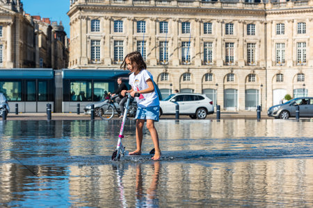 FRANCE, BORDEAUX - SEPTEMBER 20: People having fun in a mirror fountain in front of Place de la Bourse in Bordeaux, France on September 20, 2015のeditorial素材