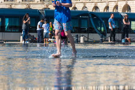 FRANCE, BORDEAUX - SEPTEMBER 20: People having fun in a mirror fountain in front of Place de la Bourse in Bordeaux, France on September 20, 2015のeditorial素材