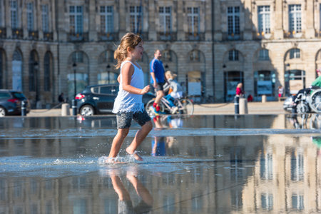 FRANCE, BORDEAUX - SEPTEMBER 20: People having fun in a mirror fountain in front of Place de la Bourse in Bordeaux, France on September 20, 2015のeditorial素材