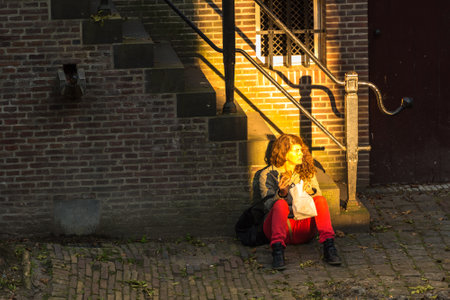 NETHERLANDS, UTRECHT - OCTOBER 01: woman sitting in light on the street of Utrecht on October 1, 2015のeditorial素材