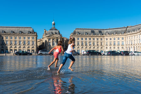 FRANCE, BORDEAUX - SEPTEMBER 20: People having fun in a mirror fountain in front of Place de la Bourse in Bordeaux, France on September 20, 2015のeditorial素材