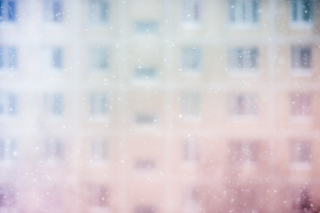Snowfall on a residential building facade background. Multi colored Defocused blur filtered shot.の写真素材