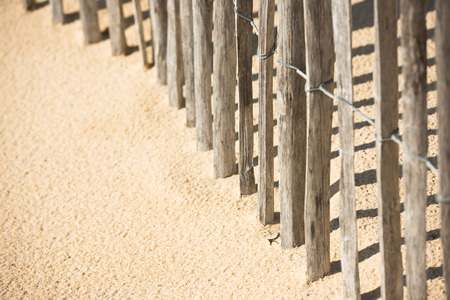 Wooden fence on an Atlantic beach in France, The Gironde Department. Shot with a selective focusの写真素材