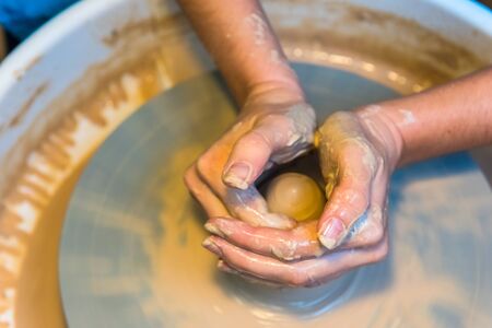 womens hands of a potter creating an earthen jarの写真素材