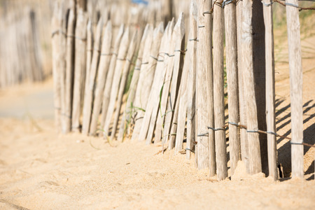 Wooden fence on an Atlantic beach in France, The Gironde Department. Shot with a selective focusの写真素材