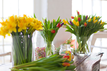 Spring flowers on a wooden table. Indoors natural light shot with small depth of field