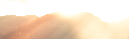 Mountains and bright sun light beams. Defocused Beautiful summer landscape with filter.