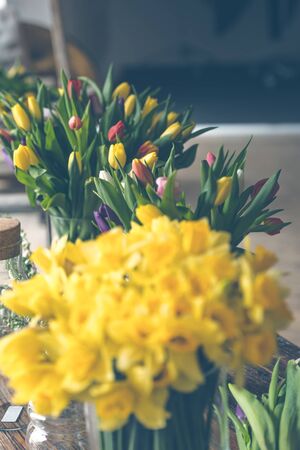Yellow narcissuses bouquet in a glass vase. Indoors natural light shot with small depth of fieldの写真素材