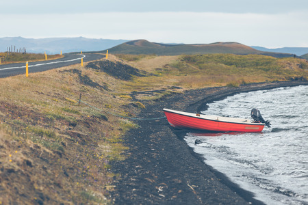 Iceland Landscape with a Red Boat on the coastの写真素材