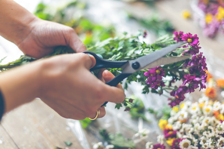 Florist making flower decoration. Indoors natural light shot with small depth of fieldの写真素材