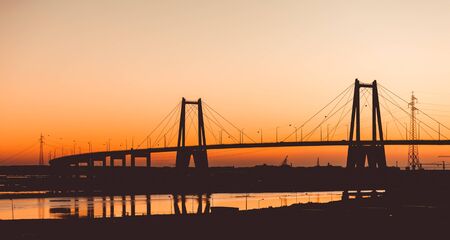 Sunset silhouette of the large suspension concrete bridge near Figueira da Foz, Portugalの写真素材