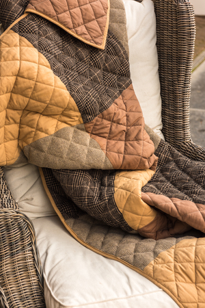 Blanket on a wicked chair outdoorsの写真素材