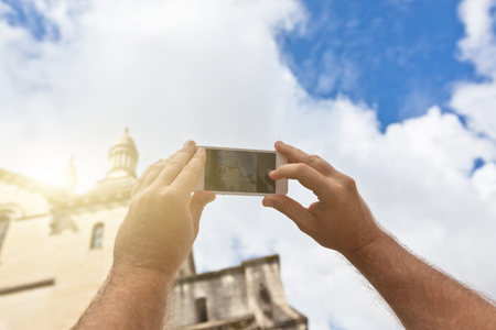 Tourist hands holding smart phone taking photo of Perigueux, France