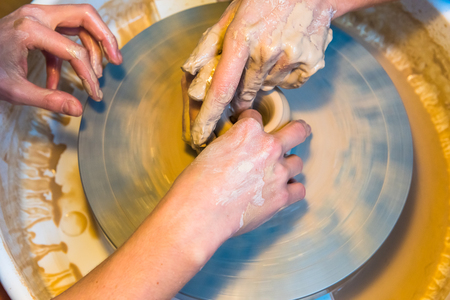 womens hands of a potter creating an earthen jarの写真素材