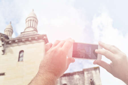 Tourist hands holding smart phone taking photo of Perigueux, Franceの写真素材