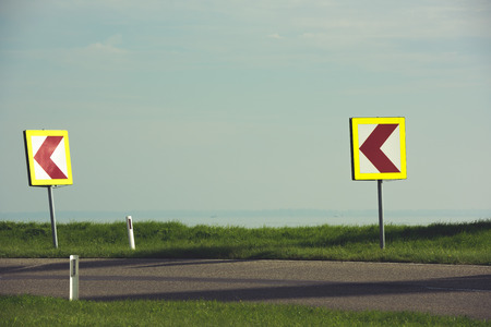 Road signs warning drivers about ahead dangerous curveの写真素材