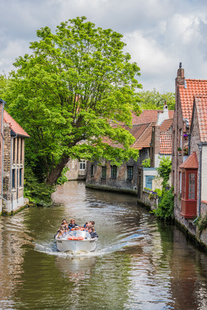 BELGIUM, BRUGES - MAY 26: boats full of tourist enjoying a beautiful canal on May 26, 2015のeditorial素材