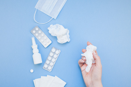 Creative flat lay concept of seasonal spring allergy with napkins, pills, face mask, drops in a...