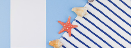 Creative long wide banner flat lay concept of summer travel vacations. Top view of beach towel and seashells and starfish on pastel blue background with copy space in minimal style, templateの写真素材