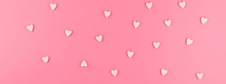 Valentines day pattern background flat lay top view of pink heart shaped candies scattered on pink...