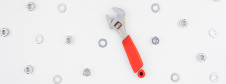 Creative long wide banner Flat lay of metal nuts and spanner on white background. Repair or improvement top view concept pattern.の写真素材