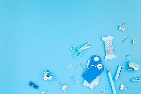 Top view flat lay of workspace desk styled design handcrafting holiday decor tags office supplies with copy space turquoise blue color paper background. Template for feminine blog social mediaの写真素材