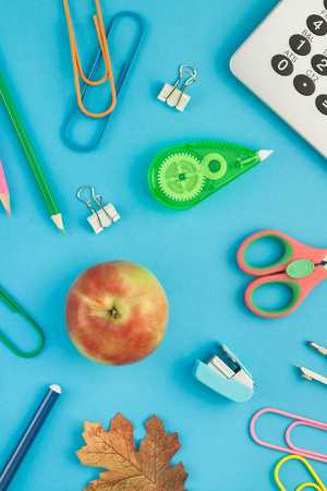 Creative flat lay top view back to school concept with alarm clock, color school and office supplies...