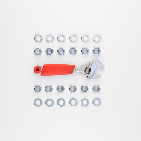 Creative square knolling Flat lay of metal nuts and spanner on white background with copy space. Repair or improvement top view concept.の写真素材
