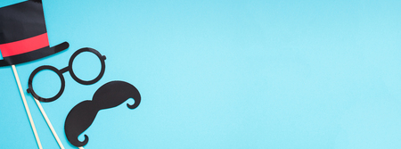 Creative long wide banner top view retro stylish black paper photo booth props moustaches turquoise background copy space. Men health awareness month fathers day masculinity concept blog social mediaの写真素材