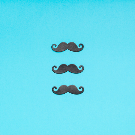 Creative square flatlay overhead top view retro stylish black paper moustaches turquoise background copy space. Men health awareness month fathers day masculinity concept blog social mediaの写真素材