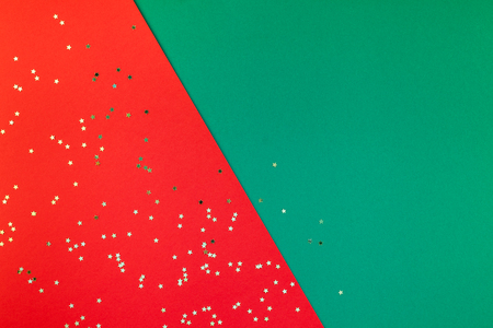 New Year or Christmas pattern flat lay top view Xmas holiday celebration red green paper golden sparkles confetti background. Template for greeting card your text design 2019の写真素材