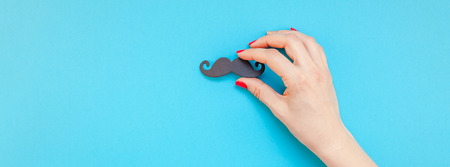 Creative flatlay top view retro black paper photo booth props moustaches woman hands turquoise background copy space. Men health awareness month fathers day masculinity concept Long wide bannerの写真素材