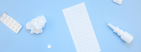 Creative flat lay concept of seasonal spring allergy with napkins, pills, face mask and drops in a bottle with copy space long wide banner minimal style, template for textの写真素材