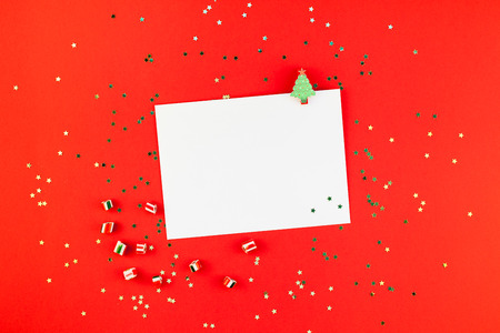 Creative New Year or Christmas greetings letter mockup flat lay top view Xmas holiday celebration envelope on red paper background golden glitter.の写真素材