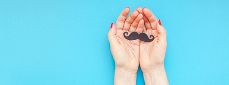 Creative flatlay top view retro black paper photo booth props moustaches woman hands turquoise background copy space.の写真素材