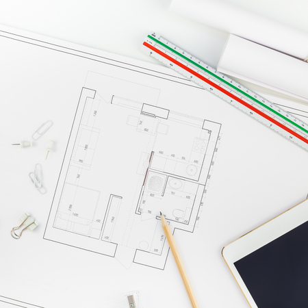 Creative flat lay overhead top view blueprints architectural flat project plan and office supplies on decorator square table workspace with swatches tools and equipment backgroundの写真素材