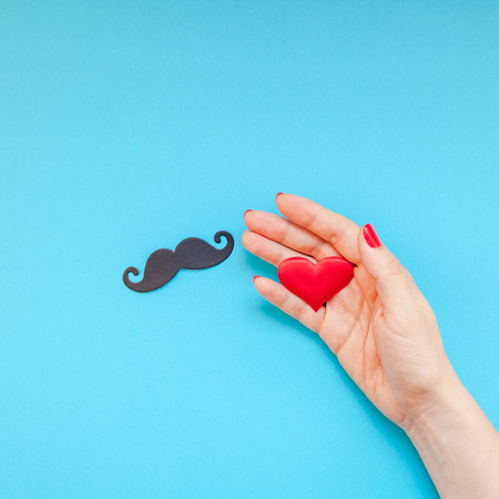 Creative square flatlay top view retro black paper photo booth props moustaches woman hands...