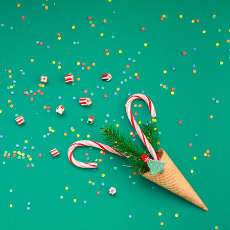 New Year Christmas Xmas holiday party celebration waffle cone candy canes fir tree branch copy space green color paper background. Square Template greeting card 2019の写真素材