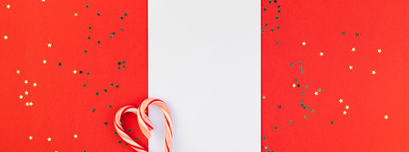 Creative New Year or Christmas greetings letter mockup flat lay top view Xmas holiday celebration envelope on red paper background golden glitter. Template mock up long wide banner 2019 2020の写真素材