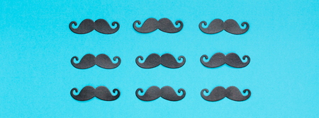 Creative flatlay overhead top view retro stylish black paper photo booth props moustaches turquoise background copy space. Men health awareness month fathers day masculinity concept long wide bannerの写真素材