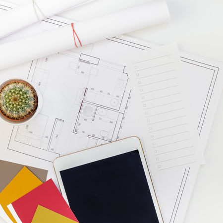 Creative flat lay overhead top view blueprints architectural flat project plan and office supplies on decorator square table workspace with swatches tools and equipment background copy space conceptの写真素材