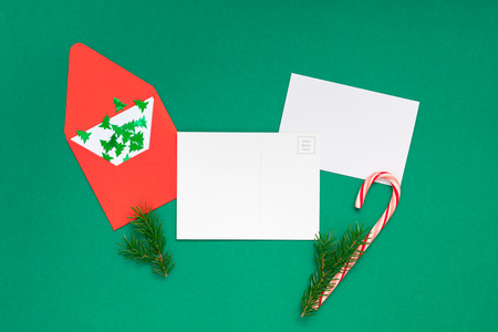 Creative New Year or Christmas greetings letter mockup flat lay top view Xmas holiday celebration envelope on green paper background. Template mock up greeting card or your text design 2019 2020の写真素材