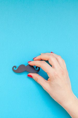 Creative flatlay top view retro black paper photo booth props moustaches woman hands turquoise background copy space. Men health awareness month fathers day masculinity concept blog social mediaの写真素材