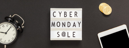 Creative Top view flat lay composition Cyber Monday sale text on lightbox alarm clock black...