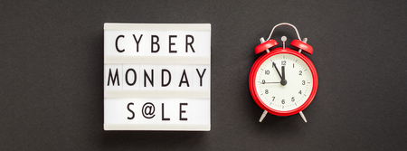 Creative Top view flat lay composition Cyber Monday sale text on lightbox alarm clock black...