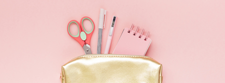 Top view flat lay of golden girl school case with office supplies with copy space millennial pink...