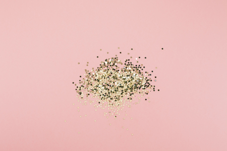 New Year or Christmas abstract Top view of golden stars confetti with copy space millennial pink color paper background minimal style. Template for feminine blog social mediaの写真素材