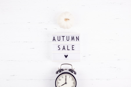 Creative Top view flat lay promotion composition Autumn sale text on lightbox white background copy space Template Autumn sale mockup fall seasonal offer promotion advertising with alarm clockの写真素材