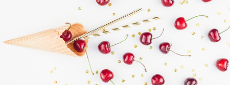 Long wide banner of ripe cherries in a waffle cone with copy space isolated on white background in...